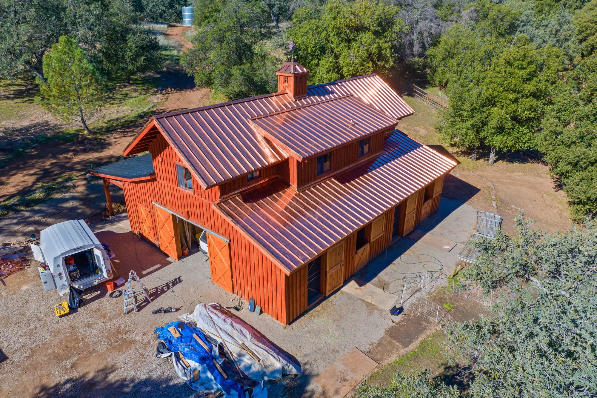 Rancho Santa Fe estate home with a copper metal roof among mature trees