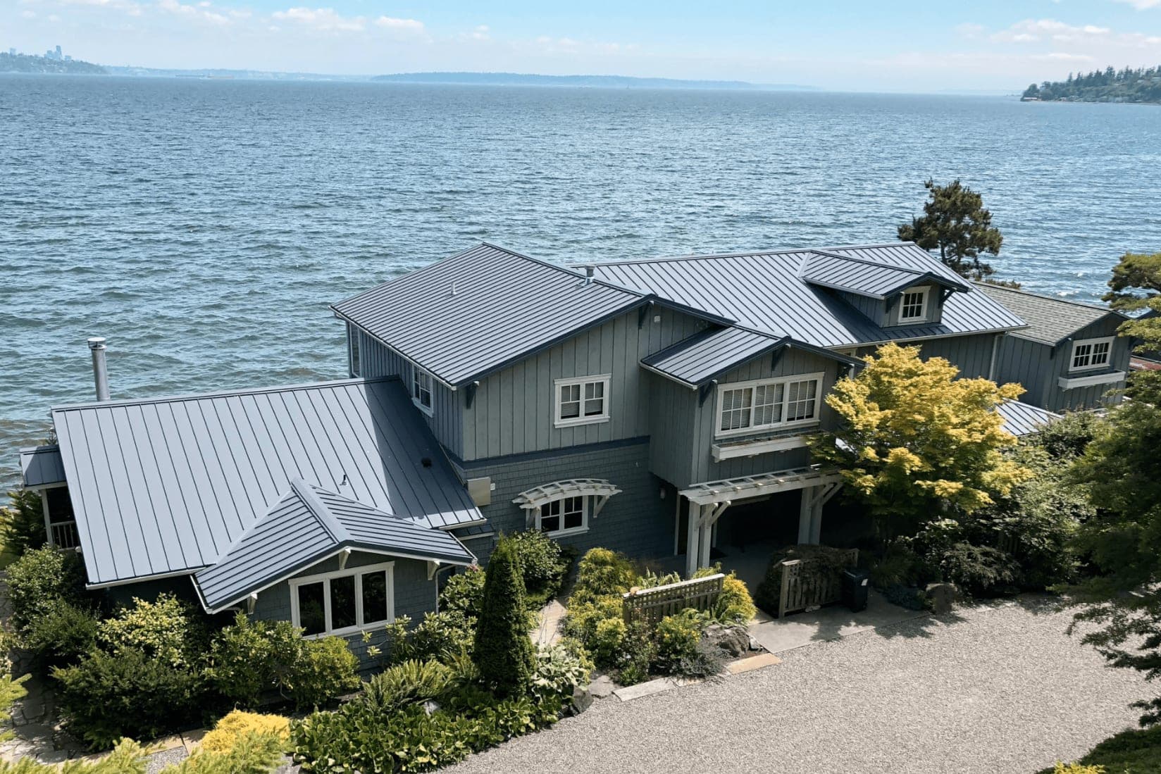 Leucadia surf cottage in Encinitas with a dark bronze standing-seam metal roof and palm trees near the beach
