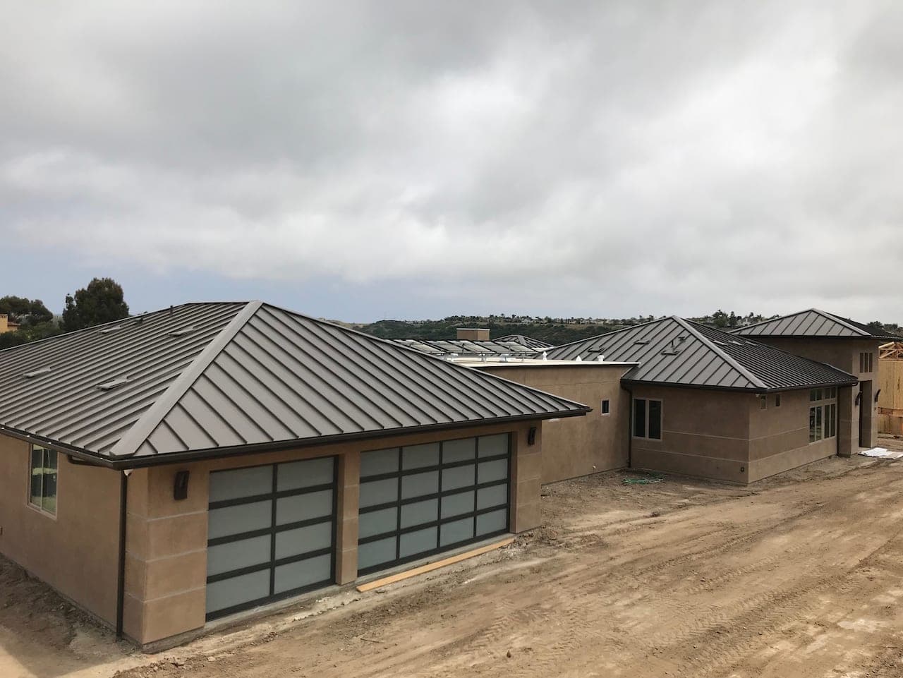 San Marcos hillside home with a standing seam metal roof below the hills