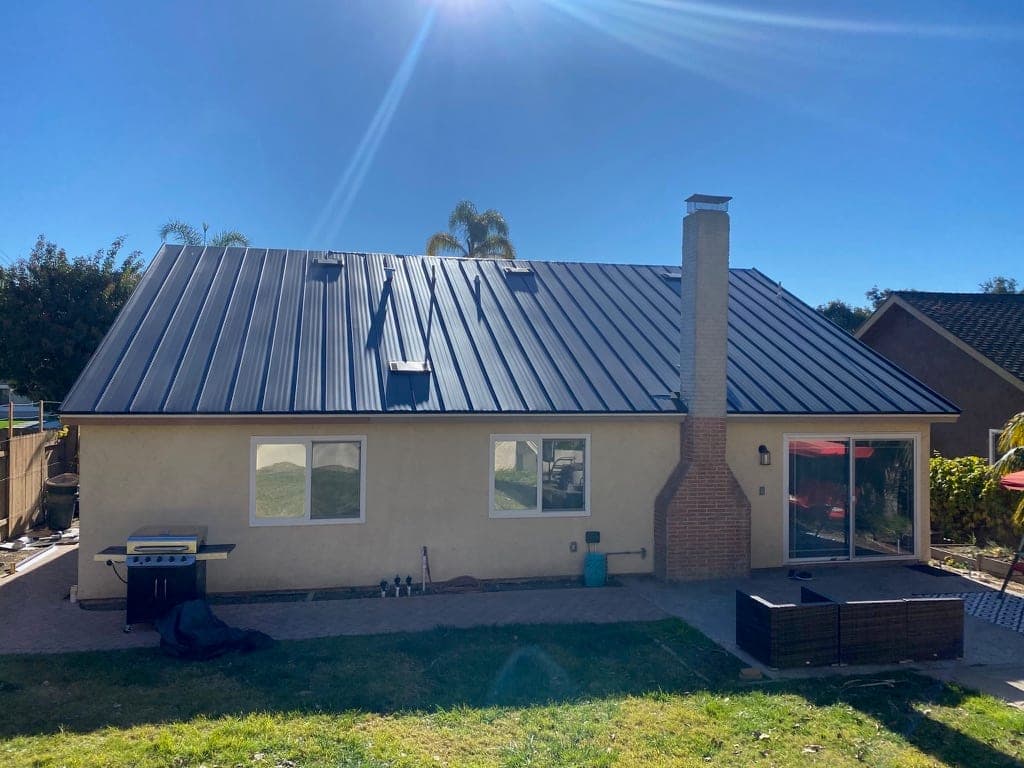 La Mesa hillside home with a metal roof and mature landscaping